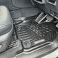Car interior with black floor mats featuring a brand logo.